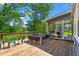 Wooden deck featuring a hot tub and screened-in porch with grill, ideal for outdoor entertaining and relaxation at 8415 Ridge Rd, Fairburn, GA 30213