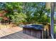 A wooden deck features a hot tub and seating, perfect for outdoor relaxation surrounded by lush trees at 8415 Ridge Rd, Fairburn, GA 30213
