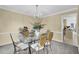 Charming dining area with a glass table, chandelier, and adjacent view into kitchen and entry at 985 Laurel Springs Ln, Marietta, GA 30064