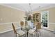 Elegant dining room with glass-top table, chandelier, and decorative china cabinet and wainscoting at 985 Laurel Springs Ln, Marietta, GA 30064