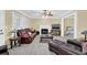 Cozy living room with a fireplace, ceiling fan, plush furniture, and plenty of natural light from the large windows at 985 Laurel Springs Ln, Marietta, GA 30064