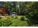 Lush backyard with green grass and landscaping, featuring a storage shed and wooded backdrop at 1268 Thomas Rd, Decatur, GA 30030