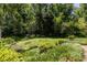 Wide backyard with mature trees and green grass, and partial landscaping at 1268 Thomas Rd, Decatur, GA 30030