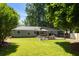 This backyard features a stone patio, string lights, a grassy area, and mature trees at 2164 Medfield Trl, Atlanta, GA 30345