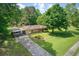 Aerial view of a ranch-style home with a long driveway, carport, mature landscaping, and well-manicured lawn at 4545 Gaydon Rd, Powder Springs, GA 30127
