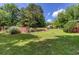 Spacious backyard featuring a well-maintained lawn, lush greenery, and a charming garden area with a wooden fence at 4545 Gaydon Rd, Powder Springs, GA 30127