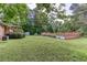 Extensive backyard with mature trees, manicured bushes, storage shed, and cozy back porch at 4545 Gaydon Rd, Powder Springs, GA 30127