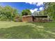 Expansive backyard with a covered patio, brick accents, wooden steps, and lush green lawn at 4545 Gaydon Rd, Powder Springs, GA 30127