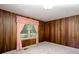 Bedroom featuring wood paneled walls, window with curtains, and carpeted floors at 4545 Gaydon Rd, Powder Springs, GA 30127