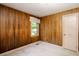 Cozy bedroom featuring wood paneled walls, a window, and neutral carpet at 4545 Gaydon Rd, Powder Springs, GA 30127