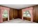 Wood paneled bedroom featuring a window with pink curtains and carpeted floors at 4545 Gaydon Rd, Powder Springs, GA 30127
