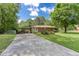 Ranch-style home with a covered carport and long driveway nestled among mature trees at 4545 Gaydon Rd, Powder Springs, GA 30127