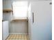 Laundry area featuring a washer, white refrigerator, shelving, and patterned floor at 4545 Gaydon Rd, Powder Springs, GA 30127