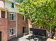 Multi-level brick home featuring a private patio with an attached garage and mature shade trees at 615 Pinetree Dr, Decatur, GA 30030