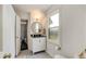 Bright bathroom with a modern vanity, round mirror, and a window providing natural light at 615 Pinetree Dr, Decatur, GA 30030