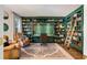 Stylish office with custom green built-ins, a cozy rug, a leather chair, and a rolling library ladder at 615 Pinetree Dr, Decatur, GA 30030