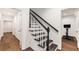 Elegant staircase with dark wood treads, white risers, and a black handrail at 615 Pinetree Dr, Decatur, GA 30030
