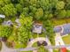 Aerial view of a home with circular driveway, manicured lawns, surrounded by lush, mature trees at 921 Oak Dr, Woodstock, GA 30189