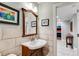 Modern bathroom with stone wall, updated vanity and fixtures, and tile floor at 921 Oak Dr, Woodstock, GA 30189