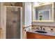 Bathroom with granite countertop, dark wood cabinets, framed mirror, and walk-in shower at 921 Oak Dr, Woodstock, GA 30189
