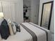 Bright bedroom featuring neutral colors, a large mirror, and ample closet space at 921 Oak Dr, Woodstock, GA 30189