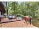 Wooden deck featuring outdoor seating, a fire pit, a red grill, and glass railings at 921 Oak Dr, Woodstock, GA 30189