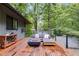 Wooden deck with outdoor seating, a fire pit, and views of the surrounding trees at 921 Oak Dr, Woodstock, GA 30189