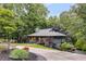 Beautiful two-story home with lush trees, modern architecture, and a spacious driveway at 921 Oak Dr, Woodstock, GA 30189