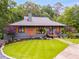 Charming home with a well-manicured lawn, lovely landscaping, and inviting front porch with great curb appeal at 921 Oak Dr, Woodstock, GA 30189
