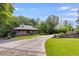 Landscaped front yard of a modern home with a long driveway and picturesque trees at 921 Oak Dr, Woodstock, GA 30189