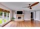 Bright living room featuring a stone fireplace, hardwood floors, and large windows with backyard views at 921 Oak Dr, Woodstock, GA 30189