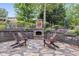 Cozy outdoor stone patio with wood burning fireplace and comfortable Adirondack seating at 921 Oak Dr, Woodstock, GA 30189