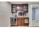Stylish wet bar featuring dark wood cabinetry, wine fridge, and marble countertops at 921 Oak Dr, Woodstock, GA 30189