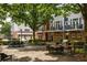 Community courtyard with tables, chairs, and barbecue grills, surrounded by townhouses at 1258 Dekalb Ne Ave # 112, Atlanta, GA 30307