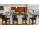 A kitchen with wooden cabinets, stainless steel appliances, and black countertops featuring barstool seating at 1258 Dekalb Ne Ave # 112, Atlanta, GA 30307