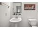 Neat powder room with pedestal sink, a square mirror and decorative artwork at 1258 Dekalb Ne Ave # 112, Atlanta, GA 30307