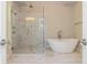 Bright bathroom with a glass shower, soaking tub and white marble floor at 2021 Towneship Trl, Roswell, GA 30075