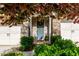 Charming front door with wreath and blue paint, flanked by white garage doors and lush green bushes at 2021 Towneship Trl, Roswell, GA 30075