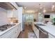 Bright open-concept kitchen features white cabinetry, a stainless steel hood, and modern appliances at 2021 Towneship Trl, Roswell, GA 30075