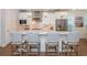 Modern kitchen featuring a large island with seating, stainless steel appliances, and stylish pendant lighting at 2021 Towneship Trl, Roswell, GA 30075