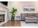 Living room featuring a cozy gray sectional sofa, modern art, and a charming fireplace at 2021 Towneship Trl, Roswell, GA 30075