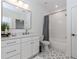 Modern bathroom featuring white vanity, gray tile floor, framed mirror, and shower with tub at 338 Sugarview Rd, Sugar Hill, GA 30518