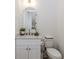 Cozy powder room showcasing a white vanity, arched mirror, and stylish fixtures at 338 Sugarview Rd, Sugar Hill, GA 30518