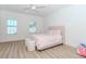 Bright bedroom with two windows, plush carpeting, and soft pink decor at 338 Sugarview Rd, Sugar Hill, GA 30518