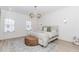 Bright main bedroom with wainscoting, chandelier, and large windows at 338 Sugarview Rd, Sugar Hill, GA 30518