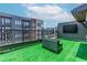 Well appointed rooftop deck features modular seating, dark metal railing, and an artificial lawn at 338 Sugarview Rd, Sugar Hill, GA 30518