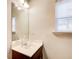 Bathroom featuring a single sink, a mirror, a window, and brown cabinets at 3622 Utoy Dr, South Fulton, GA 30331