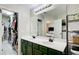 Bathroom with double sinks, a large mirror, green cabinets and a walk-in closet at 3622 Utoy Dr, South Fulton, GA 30331