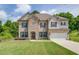 Beautiful two-story home featuring a combination of stone and siding, a manicured lawn, and an attached two-car garage at 4931 Pauls Pointe, Sugar Hill, GA 30518