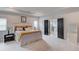 Spacious bedroom features a walk-in bathroom, a queen bed, and a dark bedside table at 4931 Pauls Pointe, Sugar Hill, GA 30518